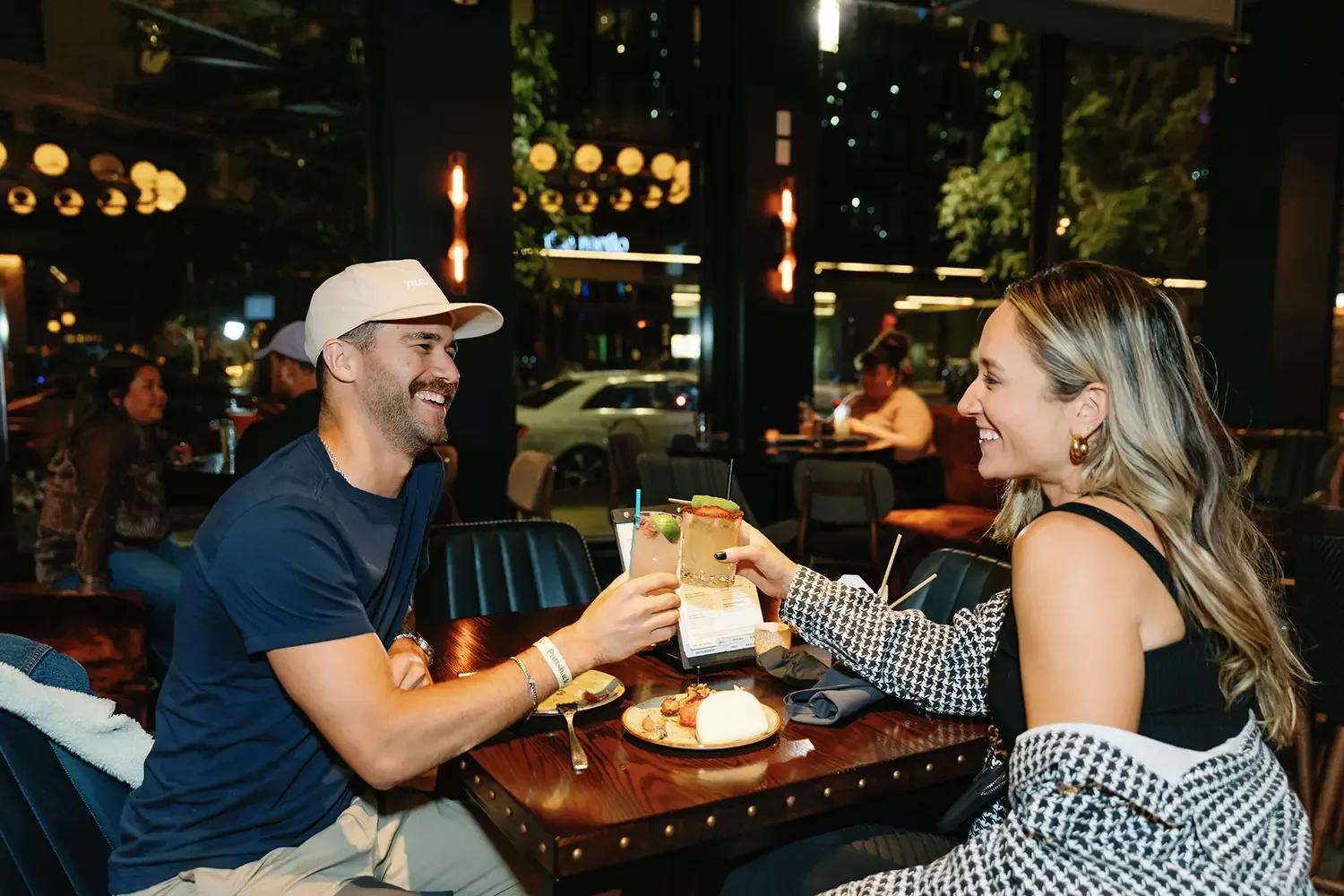 Two patrons at Puttshack laughing over drinks