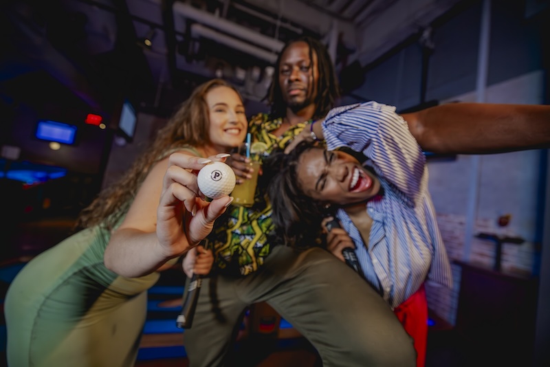 group of three friends playing mini golf